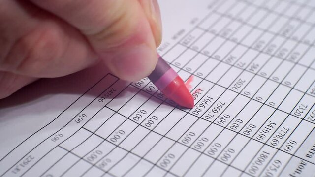 Paperwork.Hand makes notes with red marker on a sheet of paper.Close-up.