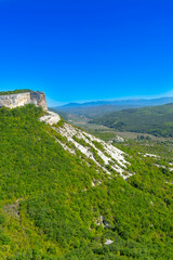 Fototapeta na wymiar Picturesque mountain valley immersed in the greenery of the forest in Crimea near the city of Bakhchisarai 