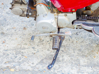 Close up photo of motorcycle running board standing on uneven asphalt