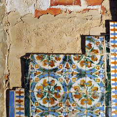 Colocación de azulejos antiguos de relieve a la manera tradicional con mortero de cal y arena sobre un muro de ladrillo. Técnicas de construcción