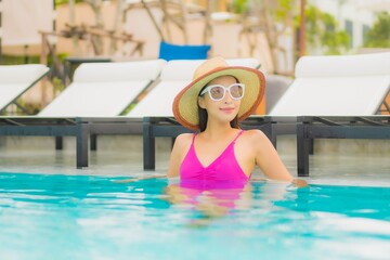 Portrait beautiful young asian woman relax smile around outdoor swimming pool in hotel resort