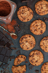 Freshly baked homemade crunchy cookies with chocolate chips, peanut butter or salted caramel. A delicious treat for gourmets. Biscuits on a baking sheet. Selective focus, top view