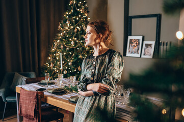 Beautiful woman in silk dress in a room with Christmas tree