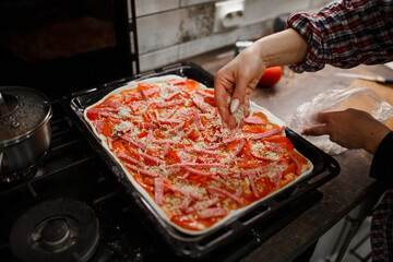 hands preparing pizza in the kitchen