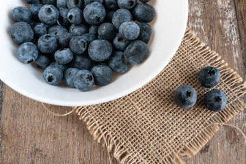 Blueberries in a white bowl on rustic table