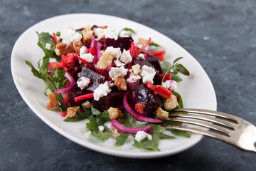 Beetroot salad with cheese and nuts in a white plate