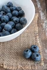 Blueberries in a white bowl on rustic table