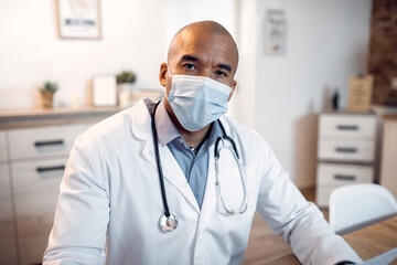 Portrait of black doctor working at his office during coronavirus pandemic.