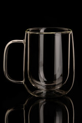 double wall glass mug on black background with reflection