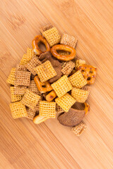 Fototapeta na wymiar Cereal holiday mix with pretzels and crunchy salty pieces in a bowl isolated over wood