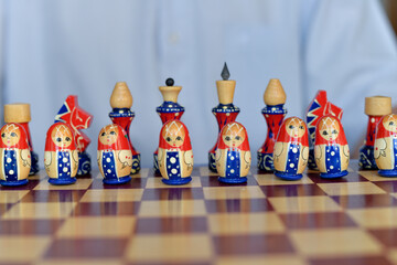 Board game of chess during self-isolation, close-up of bright matryoshka figures