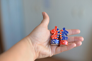 Board game of chess during self-isolation, close-up of bright matryoshka figures