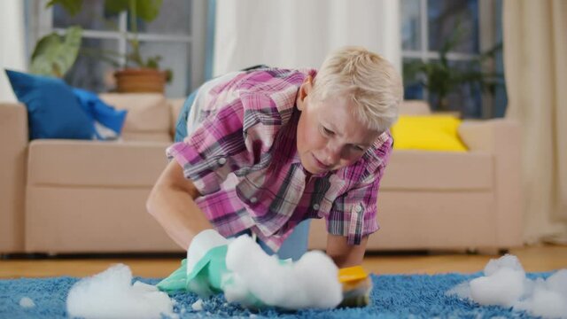 Senior woman cleaning carpet with detergent and brush in living room