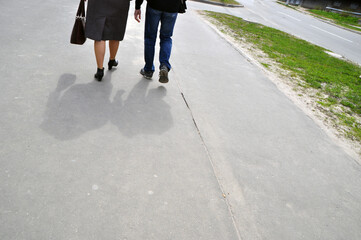 A man and a woman are walking along the road. Walk on a summer day. Stroll.