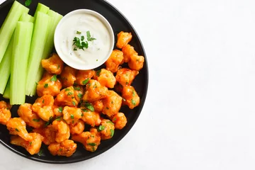 Tuinposter Cauliflower buffalo wings with celery and sauce © voltan