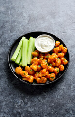 Cauliflower buffalo wings with celery and sauce