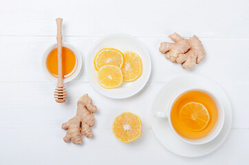 Ginger with lemonand herbal tea on white wooden background