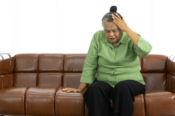 senior asian fat woman suffering from headache on sofa