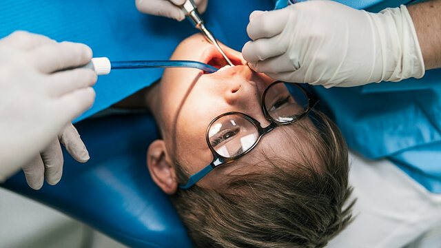 Young Boy In Dentist With Open Mouth