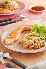 Tasty dinner or lunch, healthy asian food. Grilled Salmon with Japanese fried rice and vegetables. Salmon Chahan Rice on wooden table