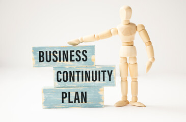 BUSINESS CONTINUITY PLAN, text on wooden block on a white BACKGROUND