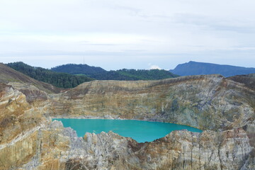 photo picture of a beautiful amazing delightful volcanic multicolor lake in the crater of a volcano Lake Kelimutu National Park Island of Flores against the backdrop of a wonderful skyline.