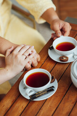 A loving couple sits in dressing gowns and drinks tea on a wooden table