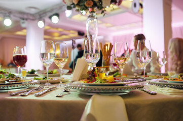 Luxurious restaurant. Luxurious interior, white tables, serving dishes and glasses for guests