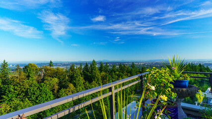 Obraz na płótnie Canvas View on a sunny summer day from BC rooftop patio garden across valley to Gulf Islands in silhouette on horizon