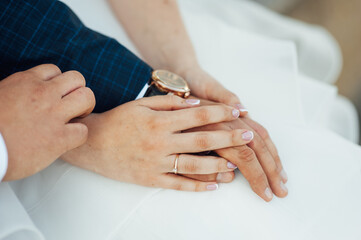close-up portrait of the bride and groom. They hug their arms. Wedding rings on their hands