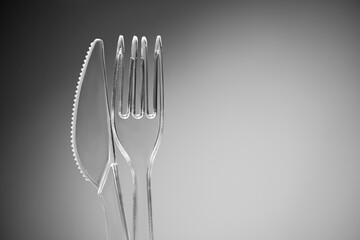 Plastic transparent fork and knife on the background