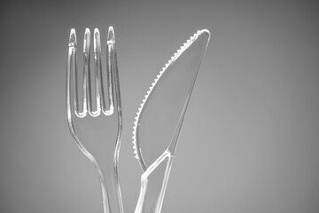 Plastic transparent fork and knife on the background
