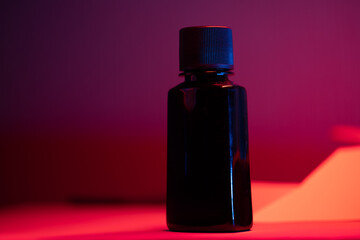 black inkbottle of black ink for manuscript on red background