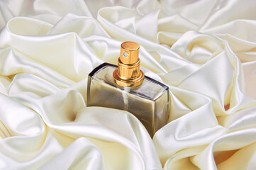 Women's perfume on a satin background. Cosmetics. Body care.