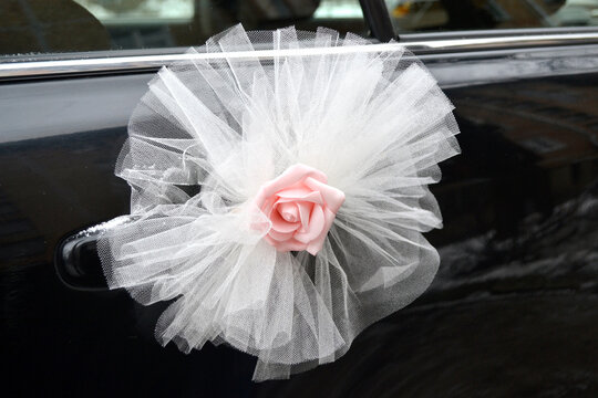 Decorative element on a door of the black car from fatin and a pink flower from foamiran.Wedding traditions