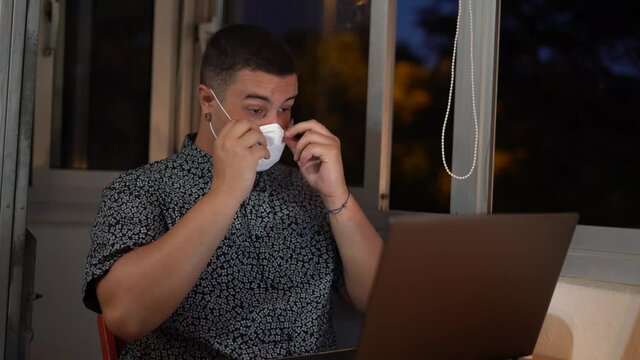 Chico joven con bigote trabajando con mascarilla por covid 19