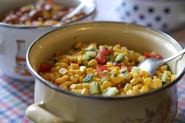 Organic vegan vegetable meal with corn,cucumbers,peper and sipces in a pot.