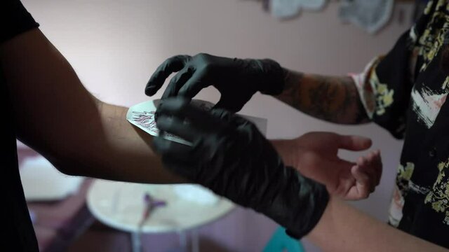 Chica joven tatuando a chico joven