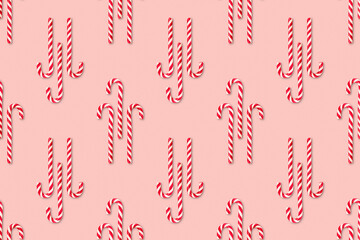 Christmas seamless pattern made of striped candy cane on a pink pastel background. Background made of food. Christmas and New year concept. Top view. Flat lay. Minimal composition