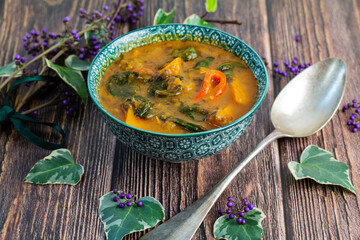 Petit bol vert de soupe marocaine sur une table en bois rustique