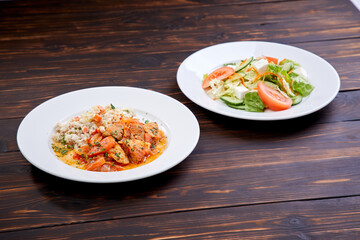 meat with barley and salad on the wooden background