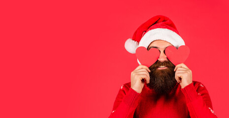 Warm Hearts. Welcome Christmas into your heart. Handsome man love winter holidays red background. Guy wear Santa hat. Merry christmas and happy new year. Fall in love. I love you. Cold Days