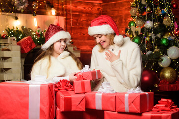 Obraz na płótnie Canvas Winter holiday. Gifts for girls. Mom and child with gift boxes. Surprise for daughter. Happy holidays. Preparing gifts for family. New year tradition. Boxing day. Wrapped gifts near christmas tree