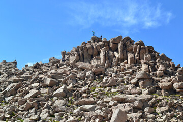 People climbing on the ridge of a rocky mountain on Mt Evans, Colorado. Rock climbing on top of...