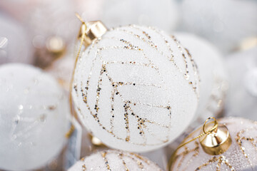 White Glass Christmas balls with golden glitters, sparkles, close up, soft focus