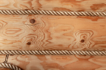 Wall of a wooden log house decorated with decorative rope. Wooden texture closeup.