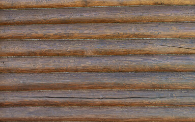 Rough wooden beams background, brown log wall texture close-up.