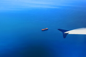 View of the Mediterranean Sea and a barge near Thessaloniki, Greece. View from the plane. Airplane wing