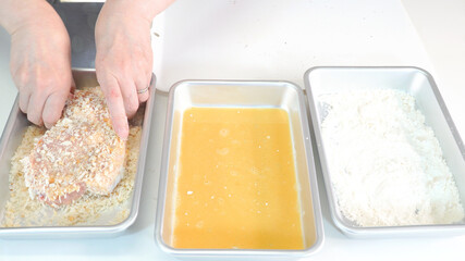 豚カツにパン粉をまぶす作業　料理シーン