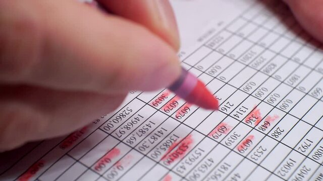Paperwork.hand makes notes with red marker on a sheet of paper.